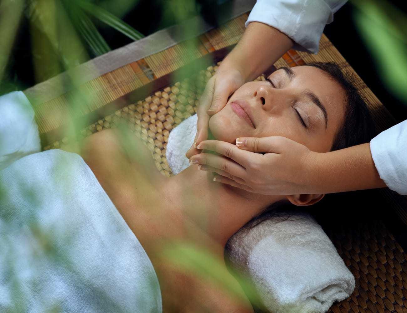 Woman receiving a relaxing facial massage at a spa.